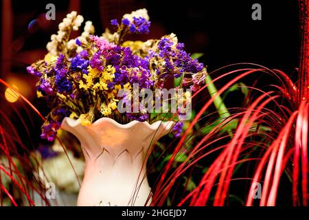 Vase with a bouquet of summer dried flowers with red threads Stock Photo