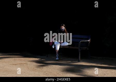 Woman sat on park bench, Sagrada Familia, Barcelona. Stock Photo
