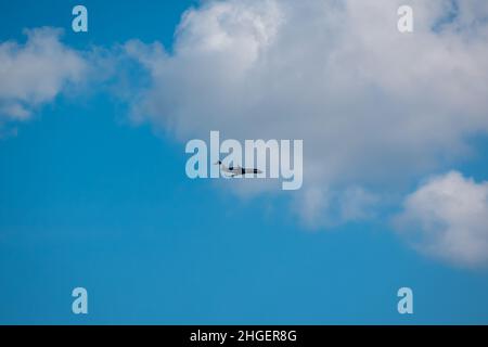 Medellin, Antioquia, Colombia - December 7 2021: Black Airplane Flying  in a Blue Sky with Clouds Stock Photo