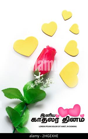 Red roses and small hearts on a white backgrounds and Valentine's Day greetings translate the Tamil text. Stock Photo