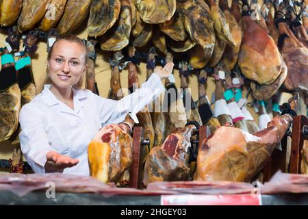 Portrait of glad woman standing in meat shop Stock Photo