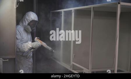 Construction worker spray paints while wearing respiratory safety ...