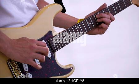 Close Up Of Man Playing Amplified Acoustic Guitar. Clip. Close-up view of hand playing guitar. Musician play on bass guitar. Stock Photo