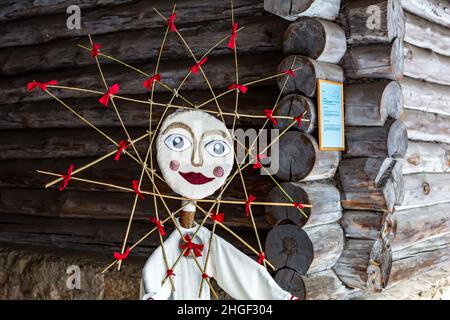 Doll in Meteņi mumming mask and costume of the Sun, with rays around head decorated with red ribbons Stock Photo