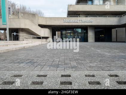 National Theatre on South Bank of the River Thames. The complex designed by Denys Lasdun was built in brutalist style. Concrete bench in foreground. Stock Photo