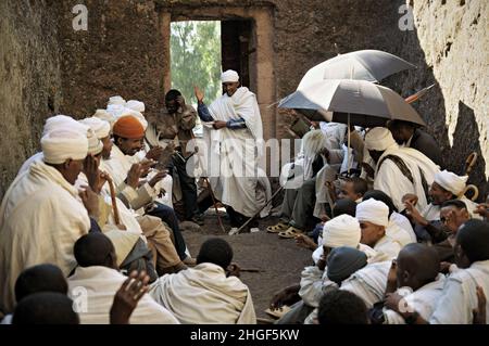 Group of priests in a cavity at Lalibela, Amhara Region, Ethiopia Stock Photo