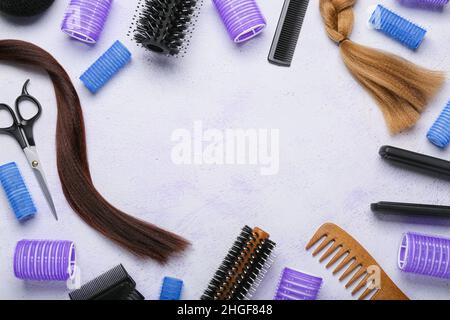 Frame made of hairdresser's tools with curlers and strands on white background Stock Photo