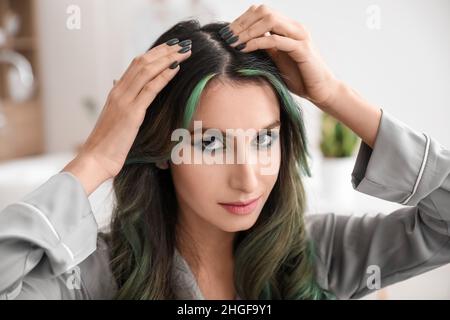 Young woman with hair loss problem in bathroom Stock Photo