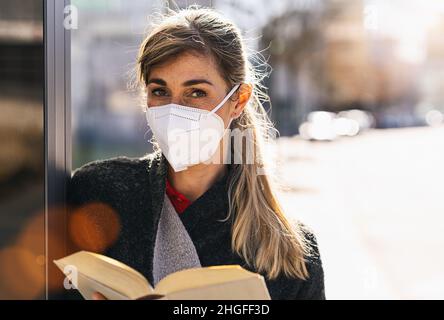 student woman wearing medical anti virus protection knN95 FFP2 face mask to prevent other from corona virus COVID-19 and SARS cov 2 infection at the c Stock Photo