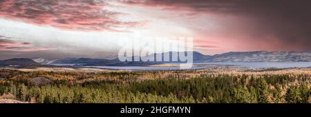 Amazing pink, orange bright pastel sunset over forest sky in northern Canada in panoramic scenic view. Taken from above, drone, aerial view. Stock Photo
