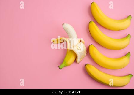 Bananas close up on light pink background with copy space for the text, flat lay. Seamless pattern bananas on a pink background Stock Photo