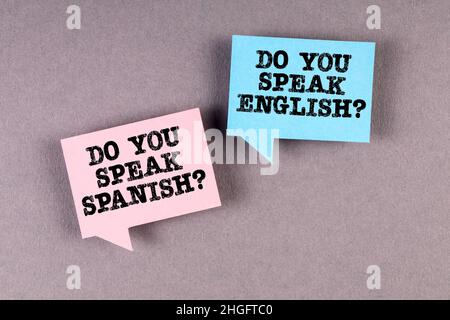 Learn and speak English and Spanish. Two speech bubbles on a gray background. Stock Photo