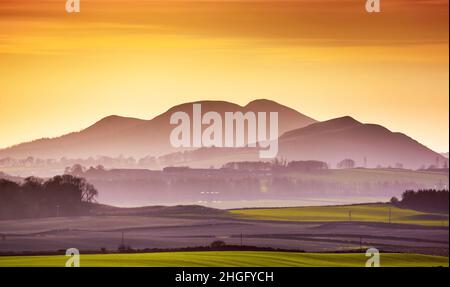 20th January 2022  Scotland UK weather.  A view looking across the farmland fields towards the Black Hill of Earlston and the Eildon Hills near Melrose in the Scottish Borders, popular trails for walkers as the sun drops on a lovely cold winters day in the Scottish Borders.  Picture Phil Wilkinson / Alamy Live News Stock Photo