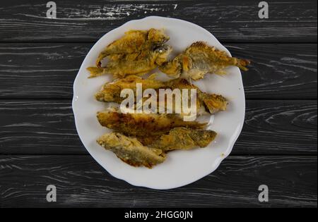 Fried fish on a wooden table Stock Photo
