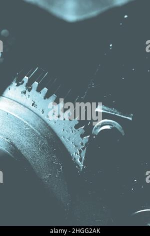 Spinning oily gearwheel as a part of an old big mechanism. Stock Photo