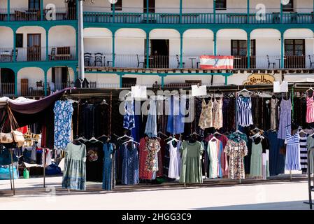 Chinchon, Spain - June 26, 2021: Clothing stalls in the street market of the Plaza Mayor of Chinchon. Sunny day of summer Stock Photo