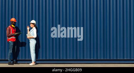 Businesswoman and engineer talking and checking loading Containers box from Cargo freight ship for import export. shipping in docks. Stock Photo
