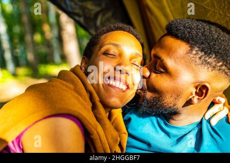 two happy african american people in love spending time outdoors in camp Stock Photo