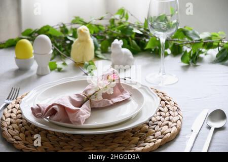 Easter table setting with yellow chick,decorations, fresh flowers and eggs. Elegance dinner. Close up. Stock Photo