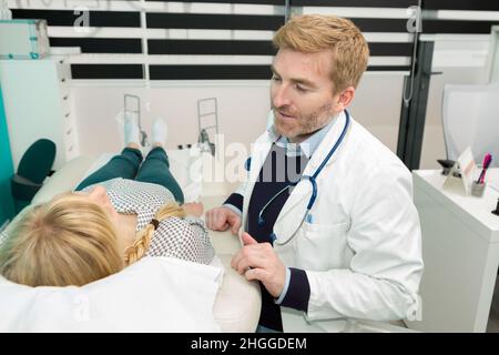 happy pregnant woman lying down on bed in hospital Stock Photo