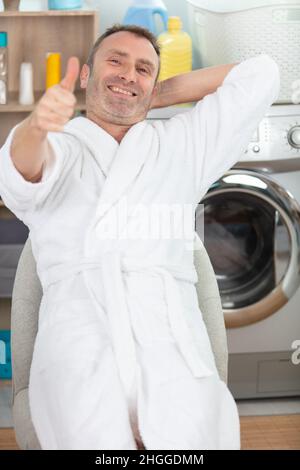 happy handsome man doing laundry Stock Photo