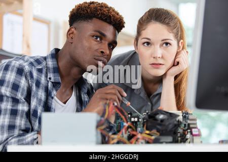 two technicians working at computer warranty center Stock Photo