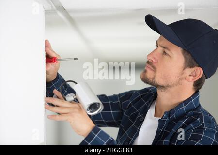 electrician installs a cctv camera Stock Photo