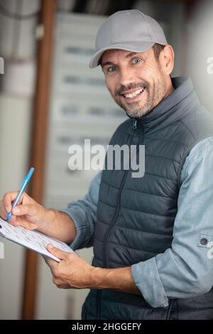 young electrician installing alarm system Stock Photo