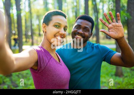 latin american couple ready to yoga time outdoors pink and blue look taking self portrait on modern smartphone hi Stock Photo