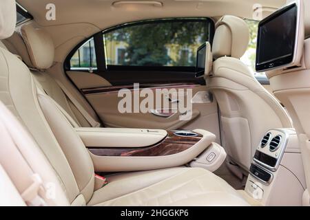 The rear seats of the luxury car in real wood and leather and the multimedia screen Stock Photo