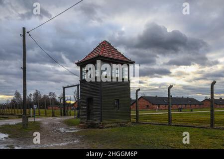 Barbed wire fence, a guard's tower and barracks at the former Nazi-German Auschwitz II-Birkenau concentration and extermination camp in Oswiecim, Poland on January 3, 2022. Stock Photo