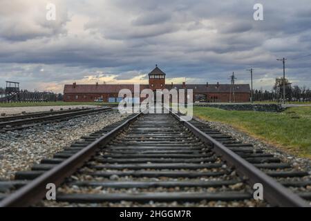 Railroad track and the Gate of Death, the main entrance at the former Nazi-German Auschwitz II-Birkenau concentration and extermination camp in Oswiecim, Poland on January 3, 2022. Stock Photo