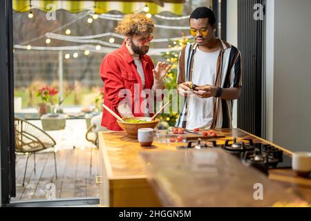 Two guys cooking healthy together at home Stock Photo
