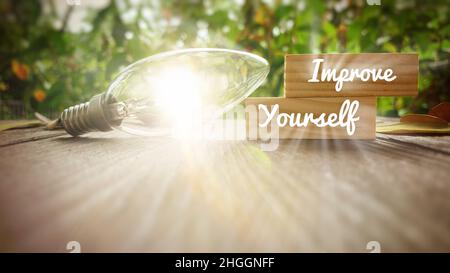 Improve yourself text on wooden blocks with shining light bulb background. Motivational concept. Stock Photo