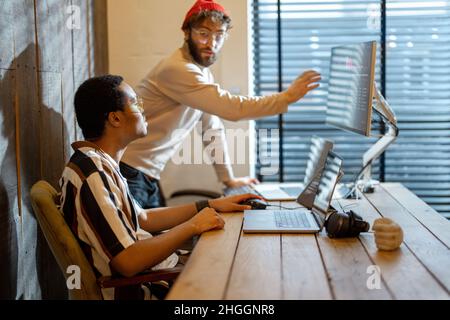 Two men working on computer at home office Stock Photo