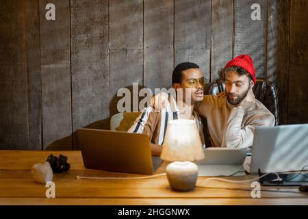 Gay couple working on computers at home office Stock Photo