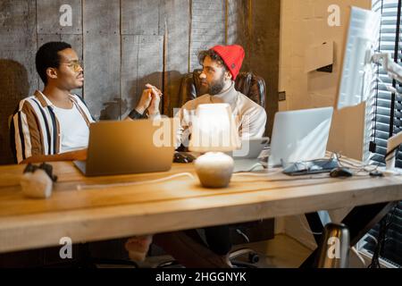Gay couple working on computers at home office Stock Photo