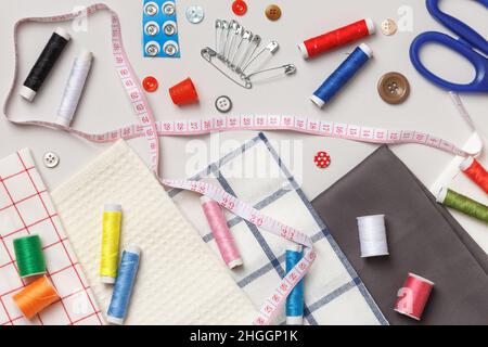 Top view of sewing tools and accessories.Fabric and threads on a gray background. Stock Photo