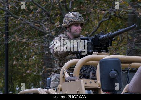 Man with combat rifle in combat gear rides on Jackal reconnaissance vehicle. Royal Yeomanry Light Cavalry Army Reserve regiment. Lord Mayor's Show. Stock Photo