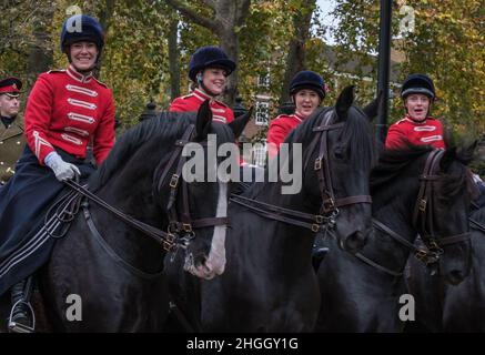 Four female riders with historic 1907 uniforms on black horses smile as they ride with The First Aid Nursing Yeomanry at the Lord Mayor's Show 2021 Stock Photo