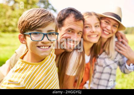 Happy boy with parents and sister as harmonious small family in nature Stock Photo