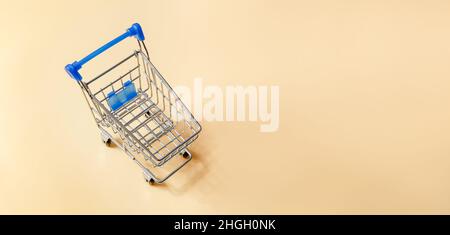 Shopping cart or supermarket trolley on yellow background, business finance shopping concept idea. fast moving consumer goods concept. Stock Photo