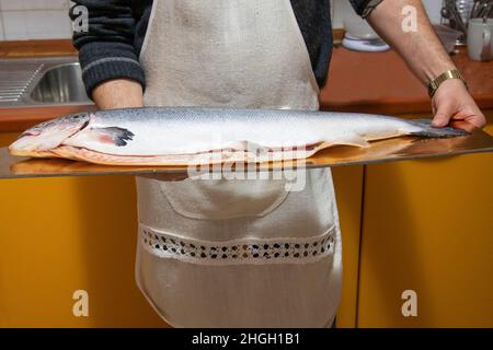 man holds big salmon fish before cooking it Stock Photo