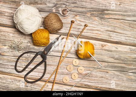Colored wool spools and crochet hooks on a wooden background with copy space Stock Photo