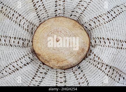 Wooden round slice on knitted natural surface Stock Photo