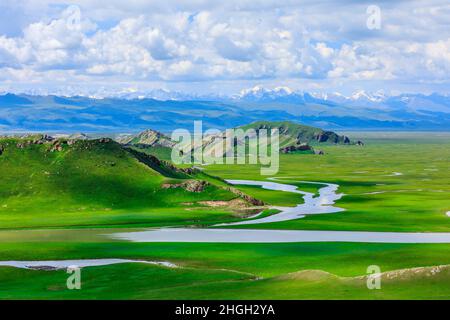 Bayinbuluke grassland natural scenery in Xinjiang,China.The winding river is on the green grassland. Stock Photo