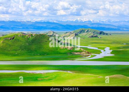 Bayinbuluke grassland natural scenery in Xinjiang,China.The winding river is on the green grassland. Stock Photo