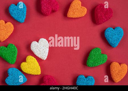 candy, top view of colorful heart shaped jelly candy sweets isolated on red background for valentines day. sweet food concept background or surface wi Stock Photo