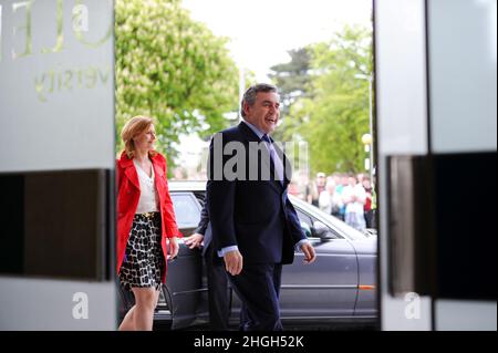 Gordon Brown visits Southampton in April 2010 when he was Prime Minister to meet general public and business leaders and held a Q&A at Solent University asking questions from voters and press. Shot showing him framed through doorway getting out of his Jaguar car along with his wife Sarah-Jane Brown smiling ready to great public. Stock Photo