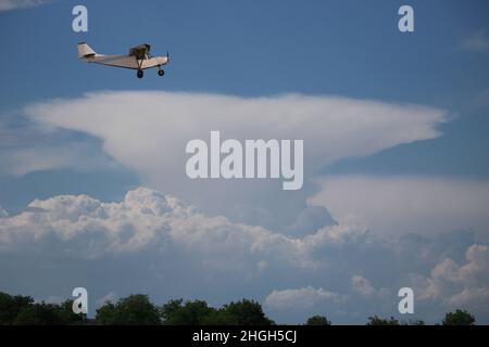 Small private single-propeller plane against the blue cloudy sky. Stock Photo
